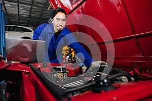 Portrait Asian Japanese male mechanic worker portrait in auto service workshop car maintenance center replace fix auto engine part