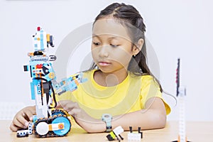 Portrait of Asian kid constructing a robot