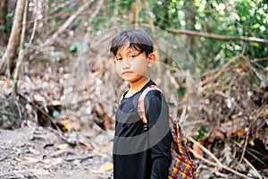 Portrait of Asian kid in green forest, jungle trekking. concept of kids vacations and travel in Bohey