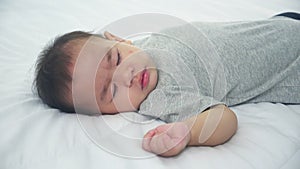 Portrait of asian little baby girl sleeping on bed in the bedroom at home, newborn napping with cozy and relax.