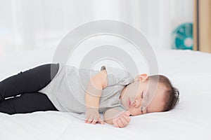 Portrait of asian little baby girl sleeping on bed in the bedroom at home, newborn napping with cozy and relax.