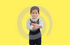 Portrait Asian little boy age 4 year old hugging a basket of color pencils isolated on yellow background. Image with Clipping path