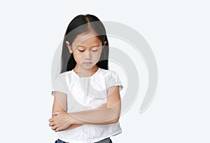 Portrait of Asian little child girl with arms crossed and acting all sad over white background with looking down. Person with
