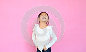 Portrait asian little child girl laughing  on pink background. Happy smiling kid expressive facial expressions