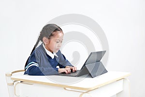 Portrait asian little child girl in school uniform using laptop on table isolated on white background, Studio shot