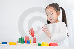 Portrait of asian little cute girl playing colorful blocks on white background