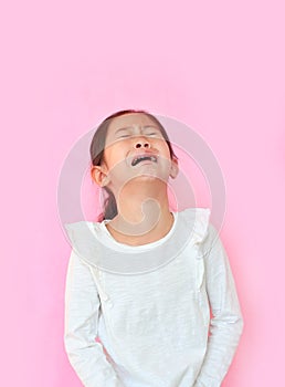 Portrait asian little girl crying isolated on pink background. Angry kid with sad expressions and screaming