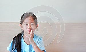 Portrait of asian little girl with expression bored face, Child with finger on cheek