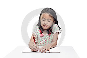 Portrait of asian little girl with pen writing in the book