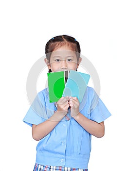 Portrait of Asian little girl in school uniform holding account book isolated on white background. Schoolgirl with bank passbook.