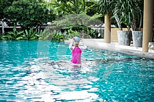 Portrait of Asian little girl swimming happily in the pool