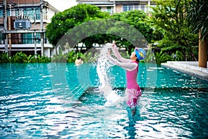 Portrait of Asian little girl swimming happily in the pool