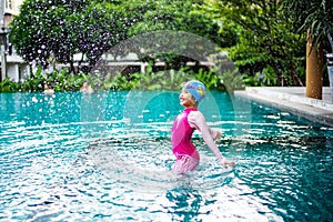 Portrait of Asian little girl swimming happily in the pool
