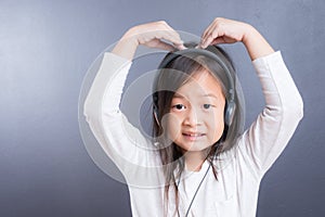 Portrait of asian little girl use headphone and smart phone
