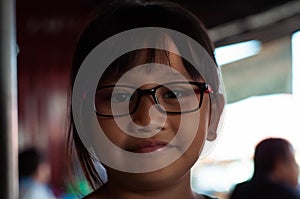 Portrait of an Asian little girl wearing glasses with sweet face
