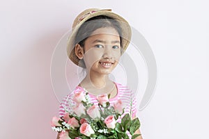 The child wears a hat and holding roses flowers with smiling and happy