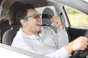 Asian Male Driver Driving His Car and Smiling photo