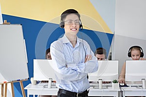 Portrait of Asian male helpdesk operator posing and smiling at call centre