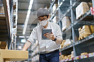 Portrait Asian men, staff, product counting Warehouse Control Manager Standing, counting and inspecting products in the warehouse