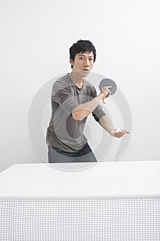 Portrait of Asian mid adult man playing table tennis