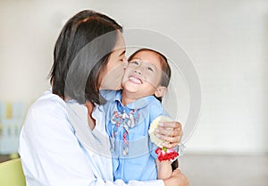 Portrait of Asian mom kissing and hugging her daughter on Mother`s day in thailand.