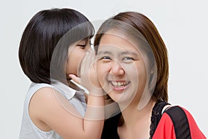 Portrait of Asian mother whispering to her daughter