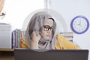 Tired Sleepy Muslim Businesswoman Waiting in Front of Her laptop