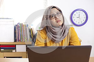 Muslim Businesswoman Working on Laptop at the Office, Thinking Gesture