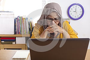 Muslim Businesswoman Working on Laptop at the Office, Thinking Gesture