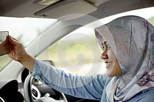 Muslim Lady Driving Her Car and Smiling photo