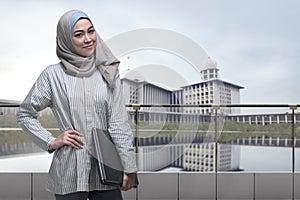 Portrait of asian muslim woman with hijab holding laptop
