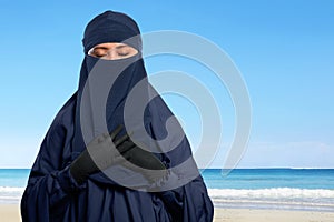 Portrait of asian muslim woman in hijab with niqab with ocean