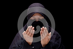 Portrait Asian Muslim woman wearing black hijab is praying for prayer with faith and determination.