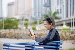 Portrait of asian office worker with ipad on bench