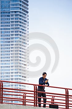 Portrait asian office worker texting mobile phone