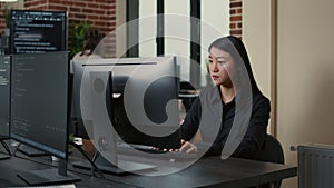 Portrait of asian programer focused on writing code sitting at desk
