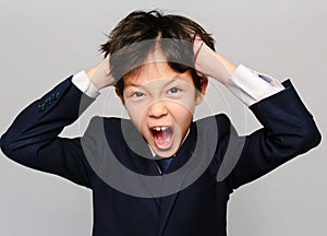 Portrait of an Asian schoolboy screaming in distress