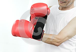 Portrait of Asian senior fighter man putting his hands into red