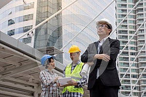 Portrait of a Asian serious engineer wearing safety helmet architects discussing construction plan