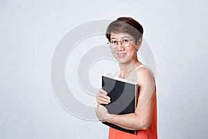 Portrait of an Asian short haired woman holding a book on white background