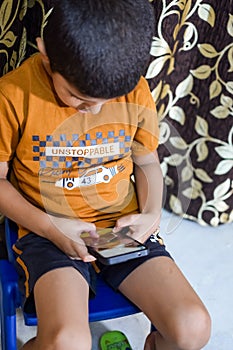 Portrait of Asian smart happy little boy using Mobile phone at home. Little boy holding mobile smart phone, online back to school
