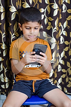 Portrait of Asian smart happy little boy using Mobile phone at home. Little boy holding mobile smart phone, online back to school