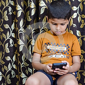 Portrait of Asian smart happy little boy using Mobile phone at home. Little boy holding mobile smart phone, online back to school