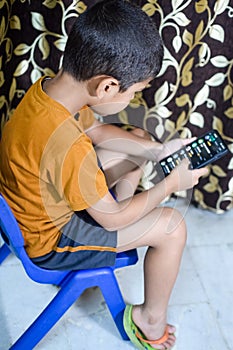 Portrait of Asian smart happy little boy using Mobile phone at home. Little boy holding mobile smart phone, online back to school