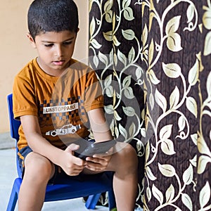 Portrait of Asian smart happy little boy using Mobile phone at home. Little boy holding mobile smart phone, online back to school