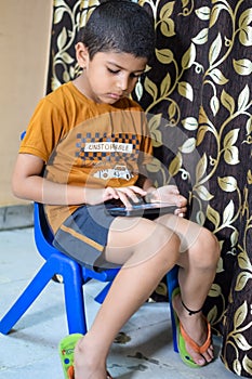 Portrait of Asian smart happy little boy using Mobile phone at home. Little boy holding mobile smart phone, online back to school