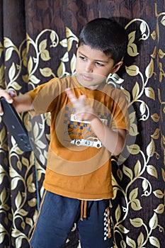 Portrait of Asian smart happy little boy using Mobile phone at home. Little boy holding mobile smart phone, online back to school