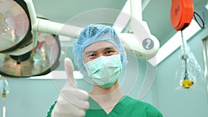 Portrait of Asian surgeon with medical mask standing in operation theater at a hospital. Team of Professional surgeons. Healthcare