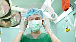 Portrait of Asian surgeon with medical mask standing in operation theater at a hospital. Team of Professional surgeons. Healthcare