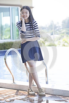 portrait of asian teen age standing beside swimming pool relaxing emotion